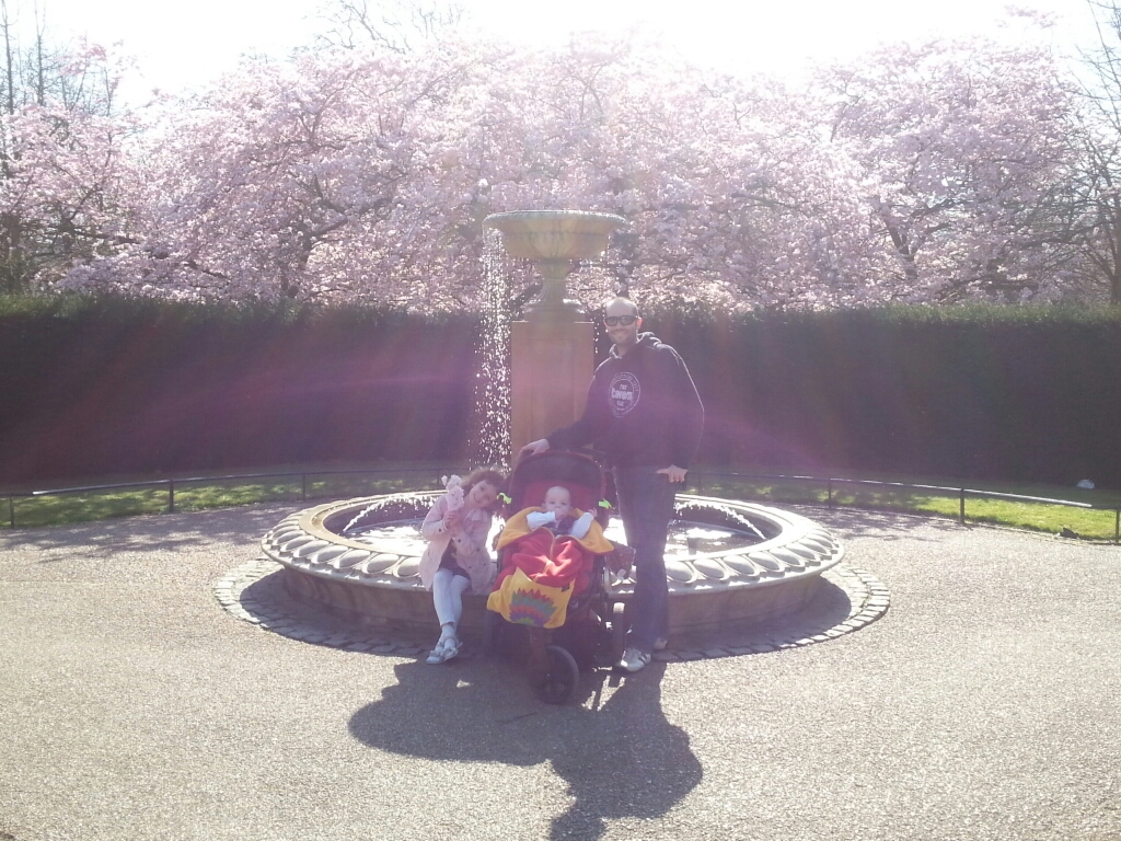 Hubs with L and C in front of fountain and blossom in Regent's Park