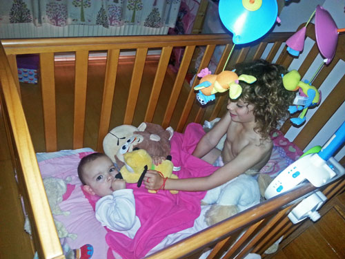 Children playing in a baby's cot. Switching off in a switched on world. www.FranglaiseMummy.com. Parenting and lifestyle blog.